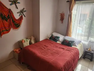 a bedroom with a bed with a red blanket and a window at Elegant Villa in La Fortuna with spacious backyard plus very private pool & parking in Fortuna