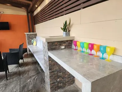 a bar with colorful chairs on a stone counter at Elegant Villa in La Fortuna with spacious backyard plus very private pool & parking in Fortuna