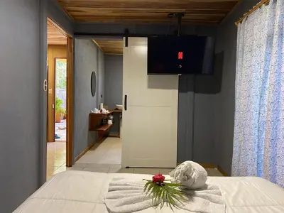 a bedroom with a bed with a stuffed animal on it at MâpleTico Casita in Monteverde Costa Rica