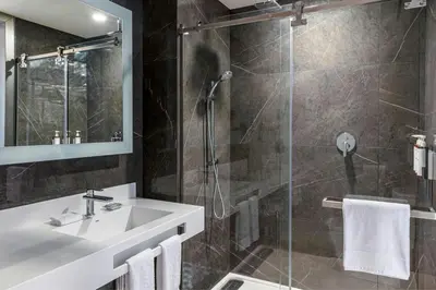 a bathroom with a sink and a shower at AC Hotel San Jose Airport Belen in San José