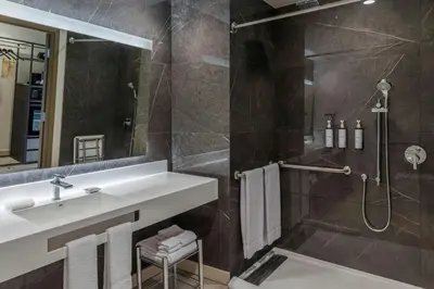 a bathroom with a sink and a shower at AC Hotel San Jose Airport Belen in San José