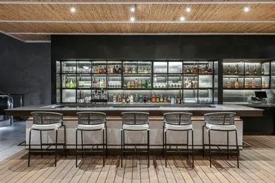 a bar with five chairs in front of a counter at AC Hotel San Jose Airport Belen in San José