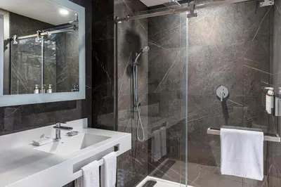 a bathroom with a sink and a shower at AC Hotel San Jose Airport Belen in San José