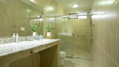 a bathroom with a shower and a sink and a toilet at Coati Arenal Lodge in Fortuna