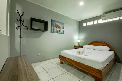 a bedroom with a bed and a table and a television at Coati Arenal Lodge in Fortuna