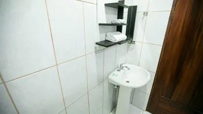 a white bathroom with a sink and a toilet at Coati Arenal Lodge in Fortuna