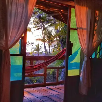 a room with a view of the ocean from a window at Ocean Forest Ecolodge in San Pedrillo