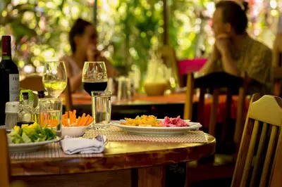 a table with plates of food and glasses of wine at Ocean Forest Ecolodge in San Pedrillo
