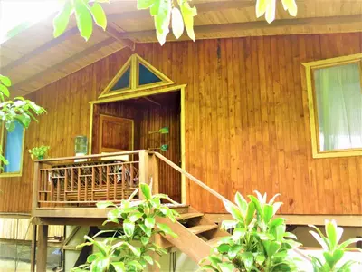 a wooden house with a staircase leading to the door at Ocean Forest Ecolodge in San Pedrillo