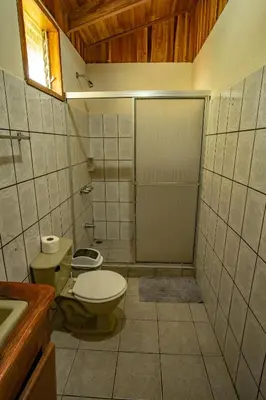 a small bathroom with a toilet and a shower at Cowboy Hostel - Habitaciones con Baño Privado in Monteverde Costa Rica