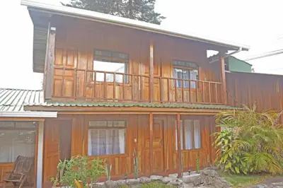 a large wooden house with a balcony on it at Cowboy Hostel - Habitaciones con Baño Privado in Monteverde Costa Rica