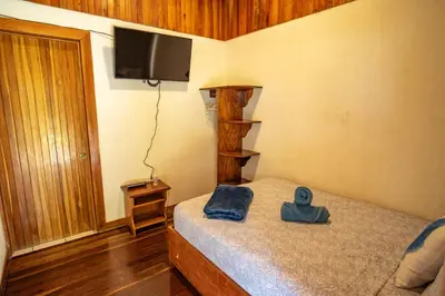 a bedroom with a bed with a hat on it at Cowboy Hostel - Habitaciones con Baño Privado in Monteverde Costa Rica