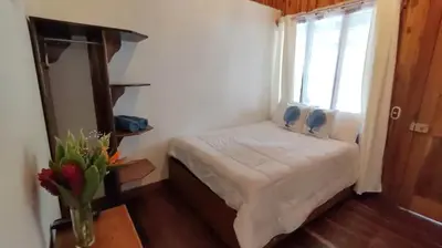 a small bedroom with a bed and a window at Cowboy Hostel - Habitaciones con Baño Privado in Monteverde Costa Rica