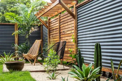 a garden with two chairs and a pergola at La Caravana in Sámara