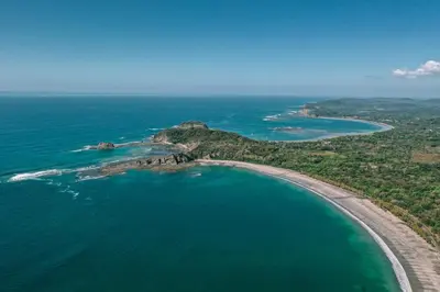 an aerial view of a small island in the ocean at La Caravana in Sámara