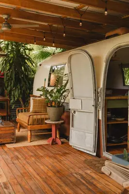 an rv with an open door and a chair and a table at La Caravana in Sámara