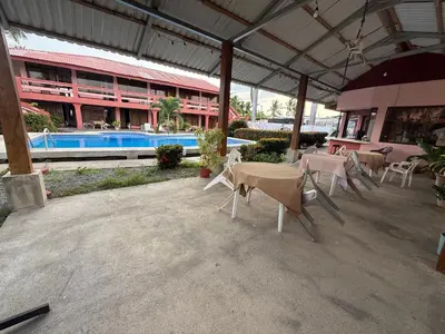 a patio with tables and chairs in front of a building at Hotel La Roca del Mar in Puntarenas