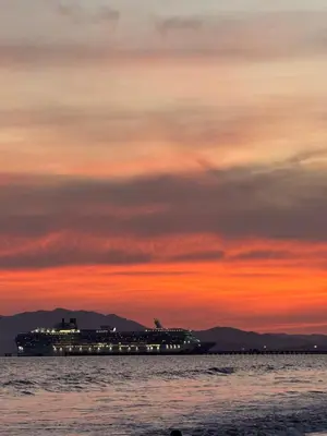 a cruise ship on the water at sunset at Hotel La Roca del Mar in Puntarenas