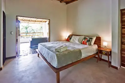 a bedroom with a large bed and a large window at Villa Ananda in Mal País