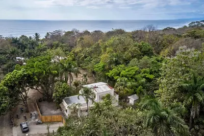 an overhead view of a house in a forest with the ocean at Villa Ananda in Mal País
