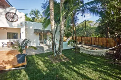 a backyard with a hammock and palm trees at Villa Ananda in Mal País
