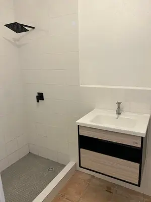 a white bathroom with a sink and a shower at Pura Vida Hostel in Tamarindo