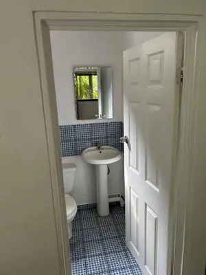 a bathroom with a sink and a toilet and a mirror at Pura Vida Hostel in Tamarindo