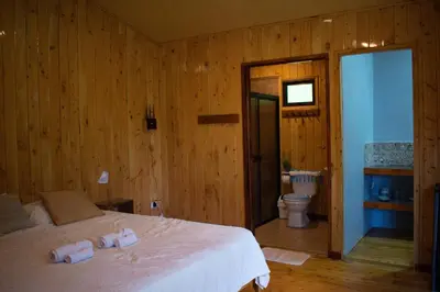 a bedroom with a bed and a bathroom with a toilet at Cabañas Lys in Monteverde Costa Rica