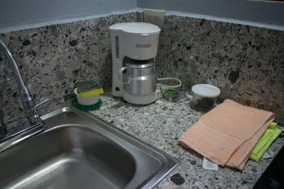 a kitchen counter with a sink and a coffee maker at Cabañas Lys in Monteverde Costa Rica