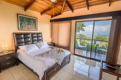 a bedroom with a bed and a large window at Barons Resort in Atenas