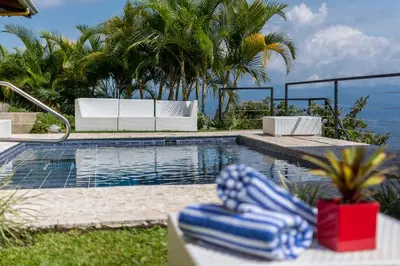 a swimming pool with blue and white lounge chairs next to it at Barons Resort in Atenas