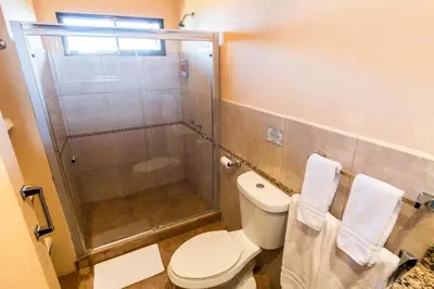 a bathroom with a toilet and a shower with towels at Barons Resort in Atenas