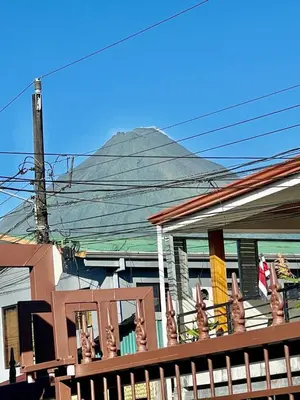 a house with a mountain in the background at Apartamentos M&M in Fortuna