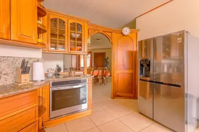 a kitchen with wooden cabinets and a stainless steel refrigerator at Casa Stela in Fortuna
