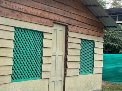 a building with two windows and a door at Beach Guesthouse in Manuel Antonio