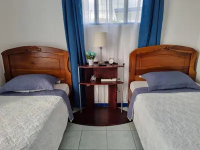 a bedroom with two beds and a table with a lamp at Entire Homy apartment for you, 5 min SJO Airport in Alajuela City