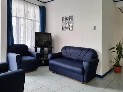 a living room with two chairs and a tv at Entire Homy apartment for you, 5 min SJO Airport in Alajuela City