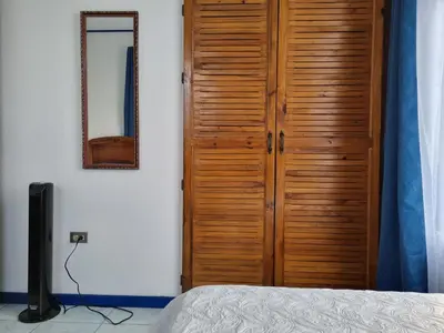 a bedroom with a wooden closet and a television at Entire Homy apartment for you, 5 min SJO Airport in Alajuela City
