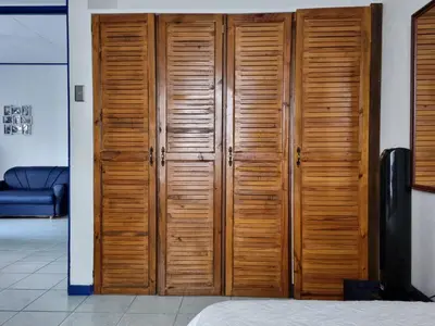 a wooden closet with wooden doors in a room at Entire Homy apartment for you, 5 min SJO Airport in Alajuela City