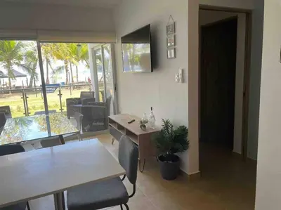 a living room with a table and chairs and a dining room at Bejuco Beachfront Condo FRENTE A LA PLAYA hermoso condominio NUEVO in Esterillos Este