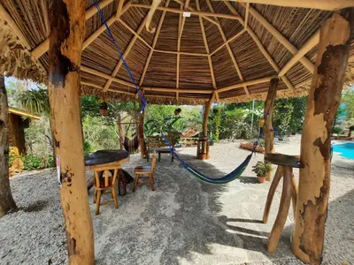 a swing in a pavilion with a table and chairs at Eco-Turismo Guayacanes in Sámara
