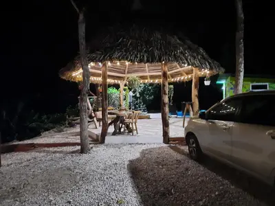 a pavilion with a table and a straw umbrella at Eco-Turismo Guayacanes in Sámara