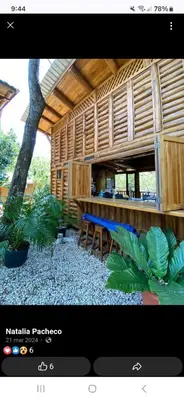 a building with a table and chairs and a tree at Eco-Turismo Guayacanes in Sámara