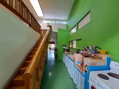 a kitchen with green walls and wooden counters and a staircase at Eco-Turismo Guayacanes in Sámara