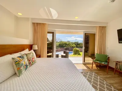 a bedroom with a bed and a view of a pool at Tropical Luxury 2Bdr condo - Pool view - At the Beach in Tamarindo