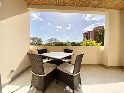 a patio with a table and chairs on a balcony at Tropical Luxury 2Bdr condo - Pool view - At the Beach in Tamarindo