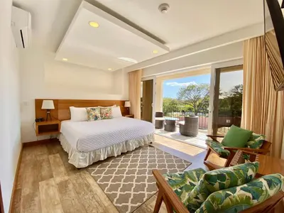 a bedroom with a bed and a large window at Tropical Luxury 2Bdr condo - Pool view - At the Beach in Tamarindo