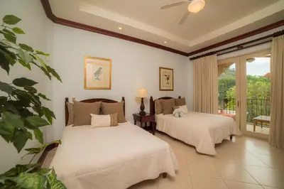 a bedroom with two beds and a balcony at Bella Vista 2D 3 bdrs pool view in Los Suenos in Herradura