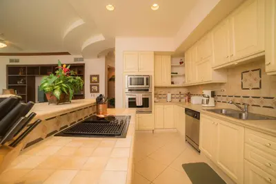 a large kitchen with white cabinets and a sink at Bella Vista 2D 3 bdrs pool view in Los Suenos in Herradura