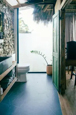 a bathroom with a toilet and a plant at THEA Resort & Retreats - Santa Teresa in Santa Teresa Beach